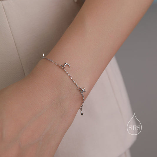 May include: A silver chain bracelet with a crescent moon and star charm.