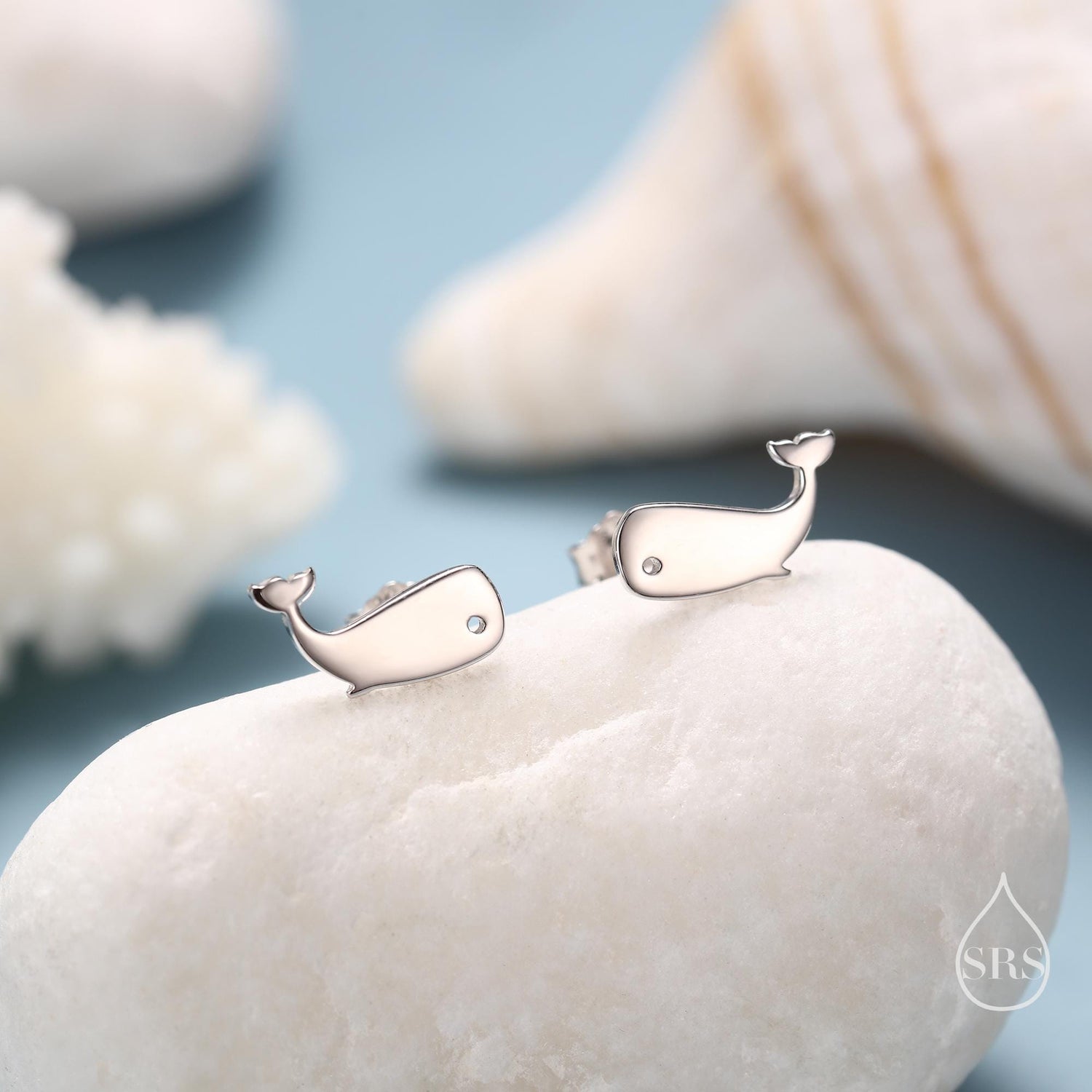 May include: A pair of silver whale stud earrings with a small clear stone in the centre of each whale.