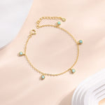 May include: A gold chain bracelet with five small round blue opal stones. The bracelet has a lobster clasp closure.